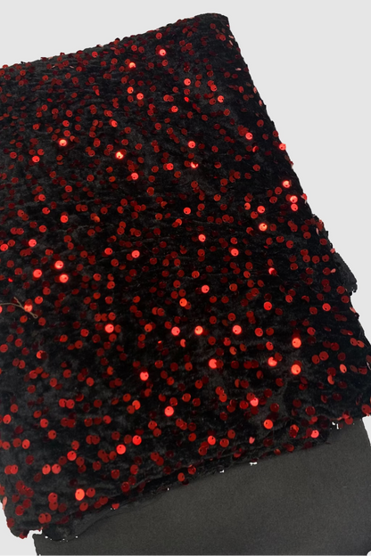 Black fabric with red sequins on a white background