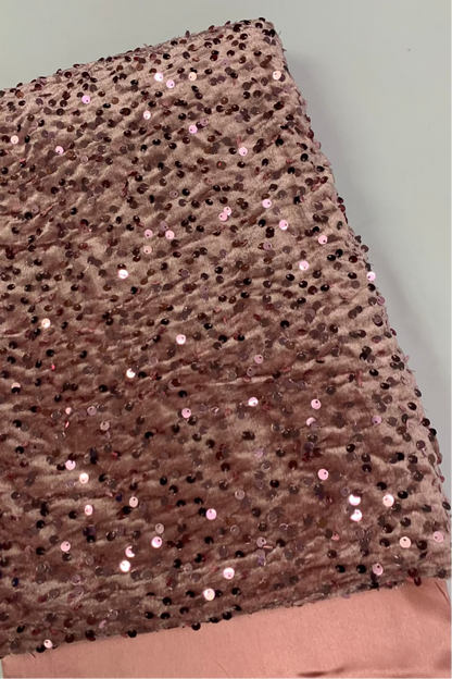 Peach velvet fabric with sequins on a light grey background