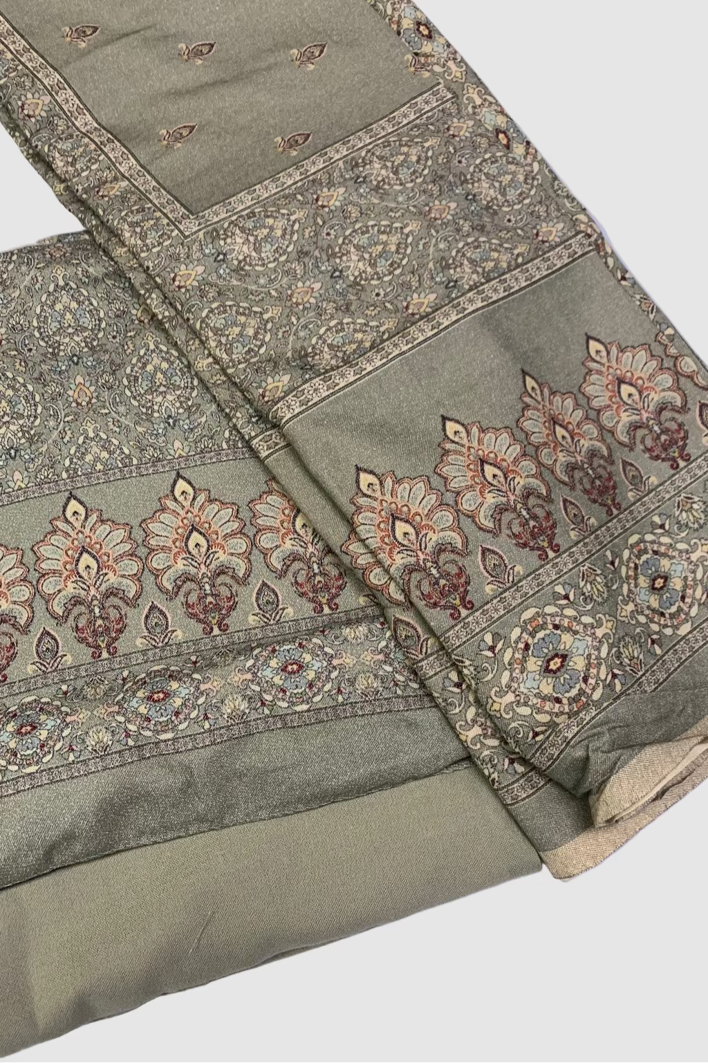 Green fabric with intricate patterns on a white background