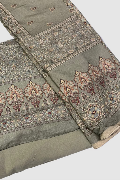 Green fabric with intricate patterns on a white background