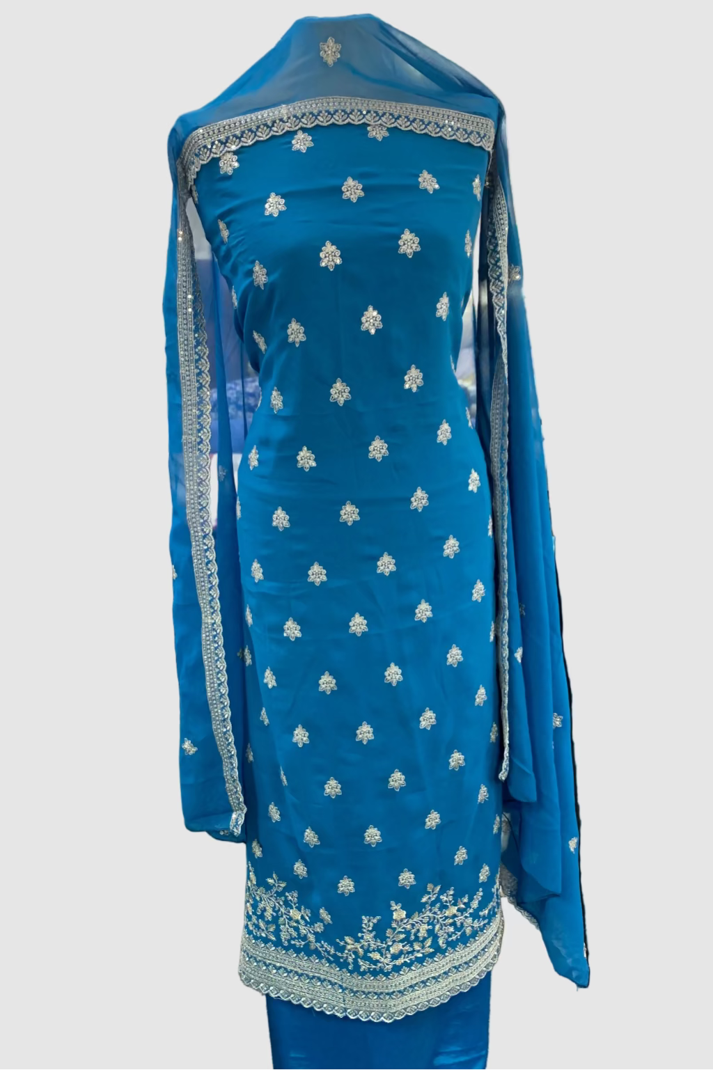 Blue embroidered traditional outfit in a store setting