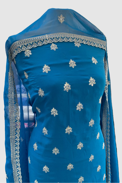 Blue embroidered garment on a mannequin in a store setting