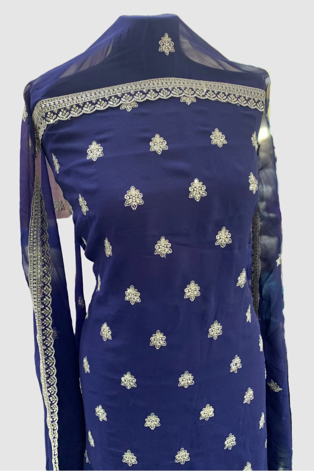 Blue embroidered fabric on a mannequin in a store setting