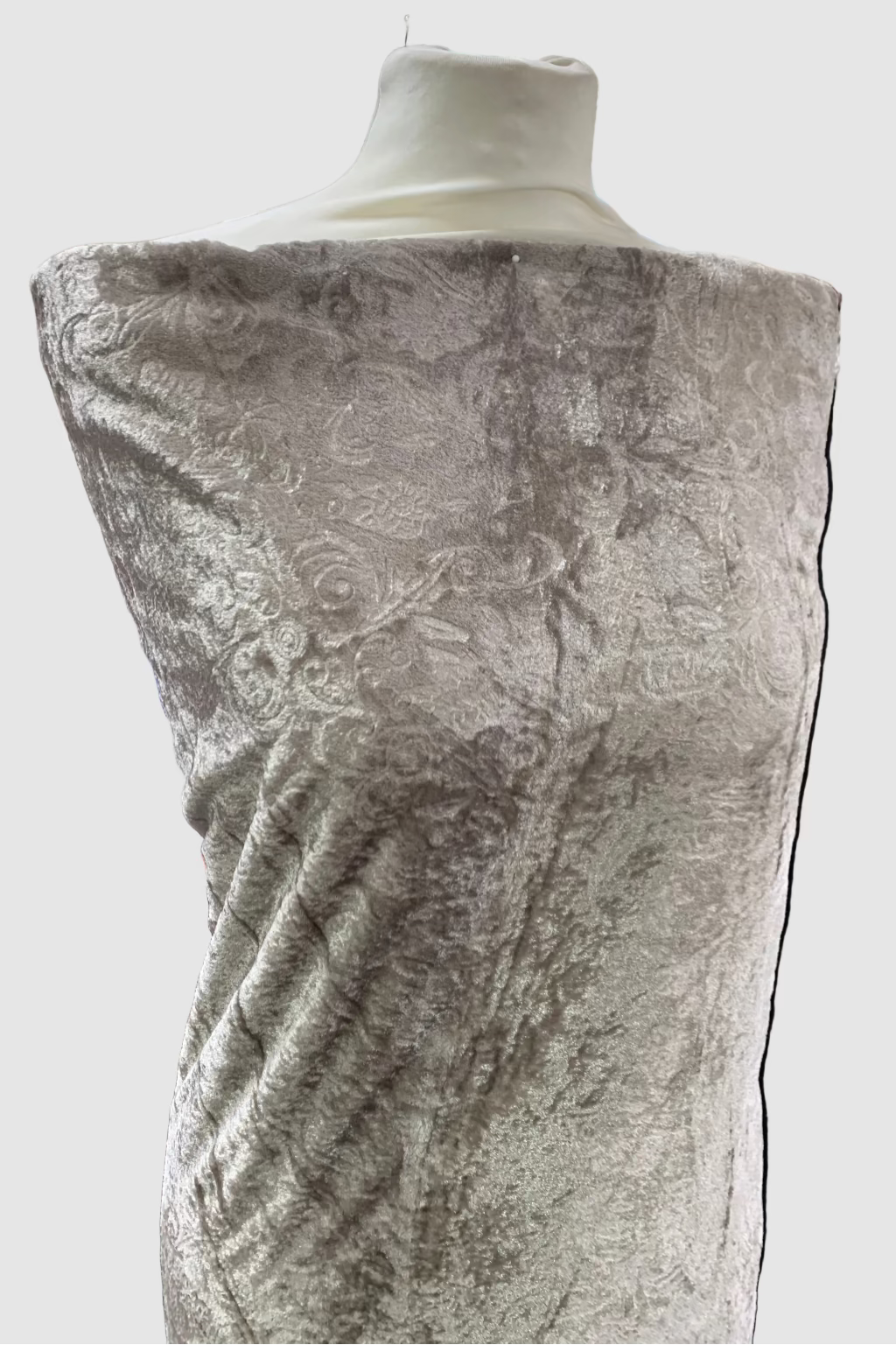 Taupe velvet fabric draped over a mannequin in a store setting