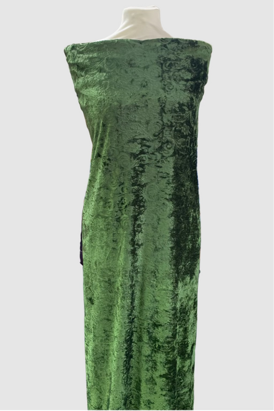 Green velvet fabric on a mannequin in a fabric store