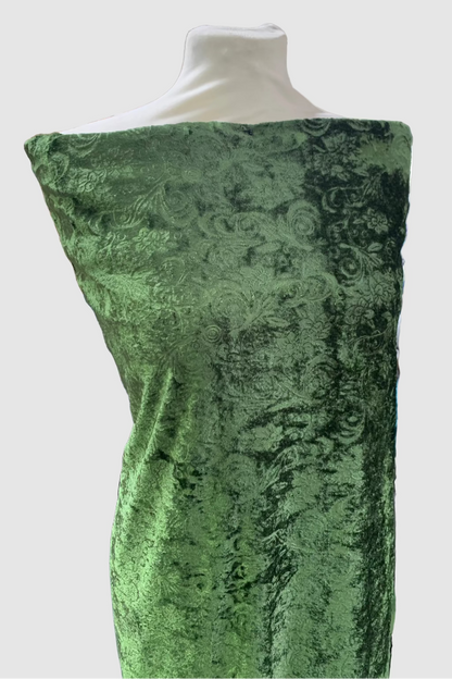 Green velvet fabric on a mannequin in a store setting