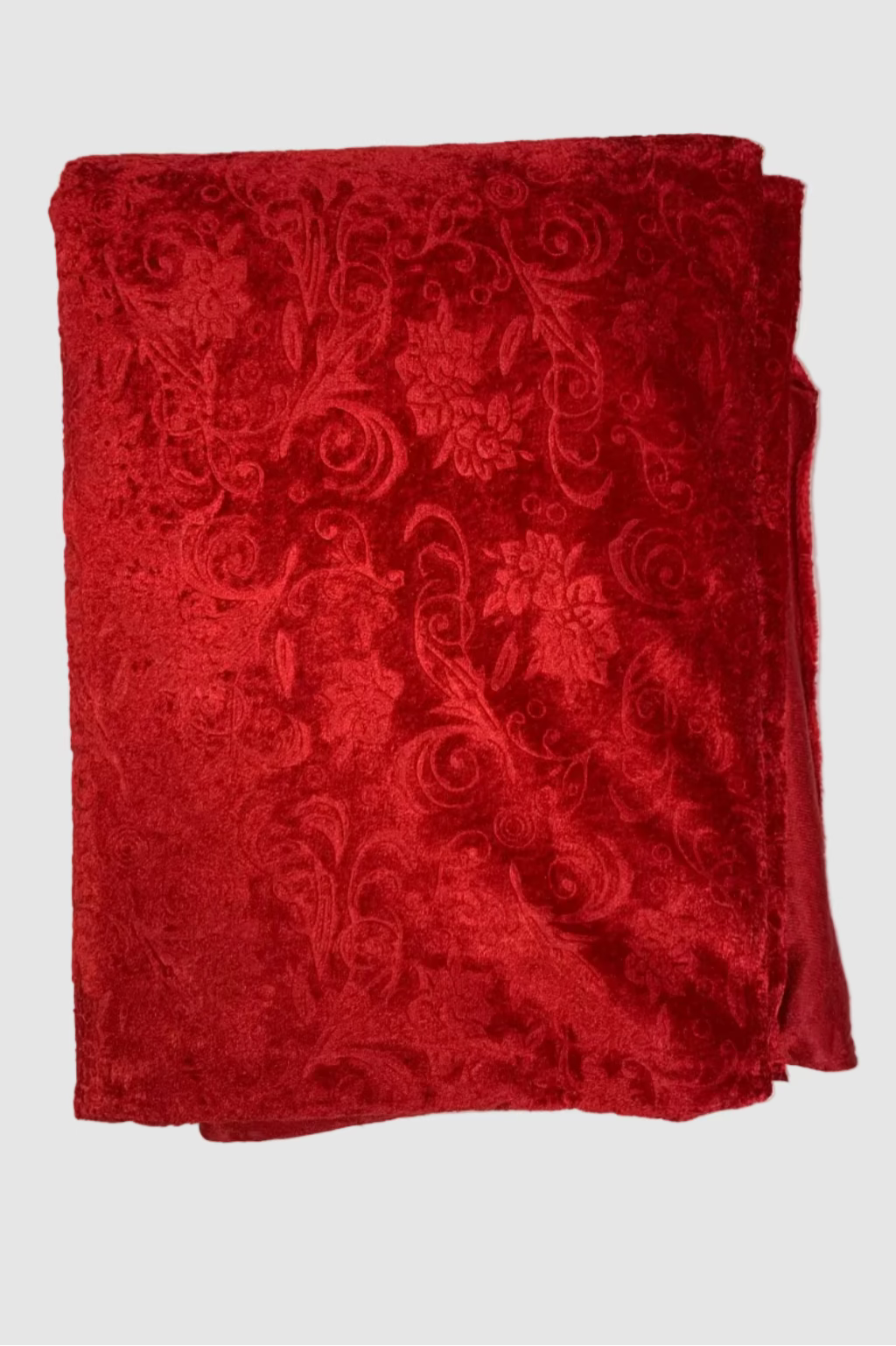 Folded red fabric with intricate patterns on a white background