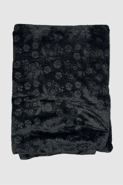 Black floral patterned fabric on a light beige background