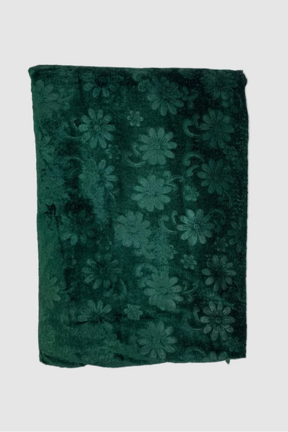 Folded green fabric with floral pattern on a white background