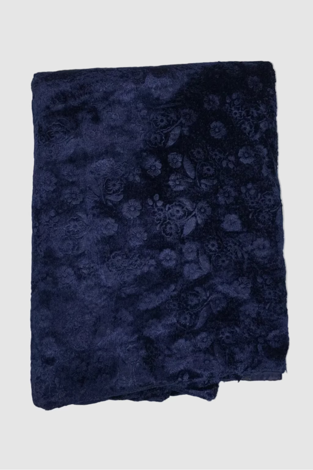 Folded navy blue fabric with floral pattern on a light gray background