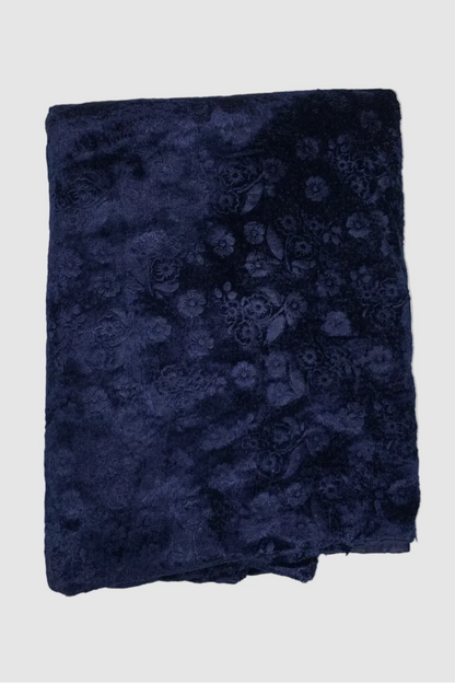 Folded navy blue fabric with floral pattern on a light gray background
