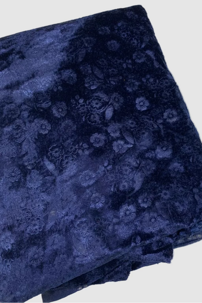 Folded navy blue fabric with floral pattern on a white background