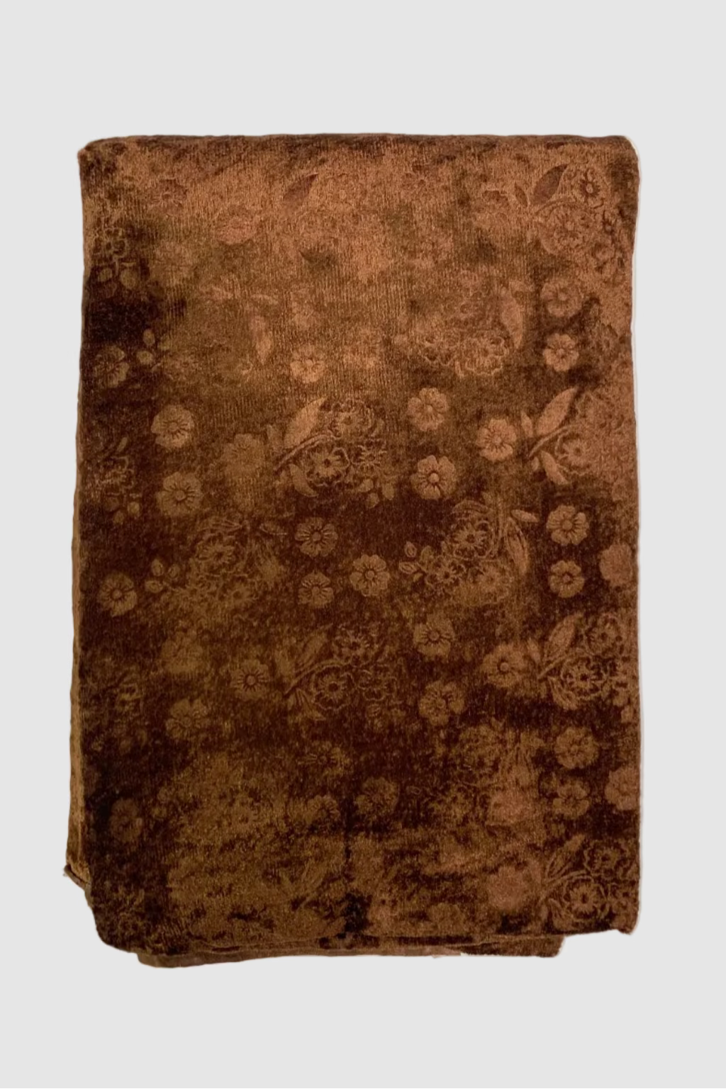 Folded brown fabric with floral pattern on a white background