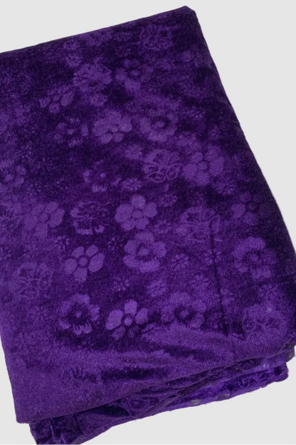 Folded purple fabric with floral pattern on a white background
