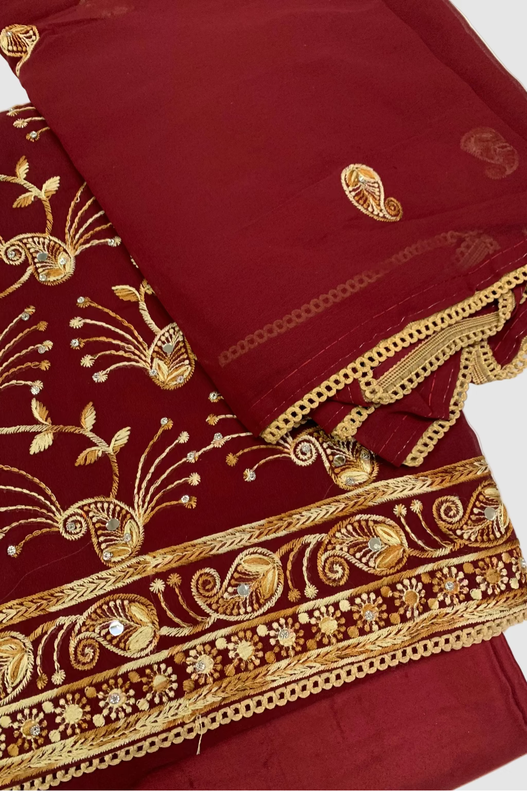 Maroon fabric with gold embroidery on a white background