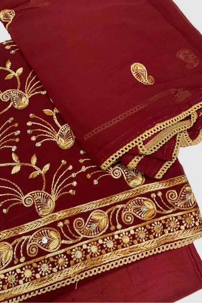 Maroon fabric with gold embroidery on a white background