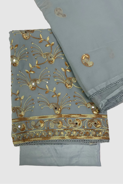 Light blue fabric with gold embroidery on a beige background