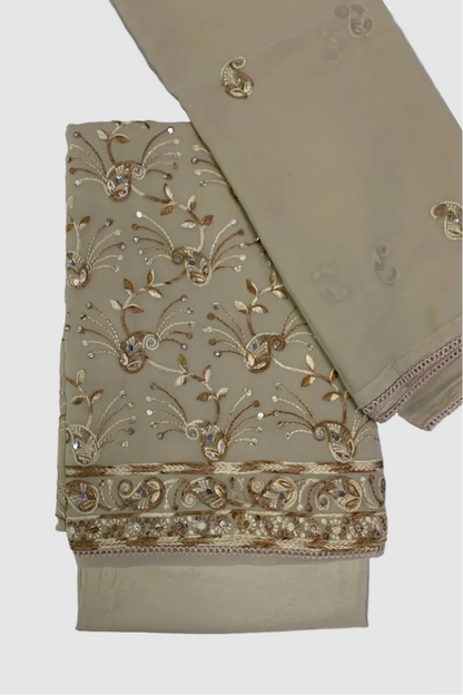 Beige fabric with intricate gold embroidery on a white background