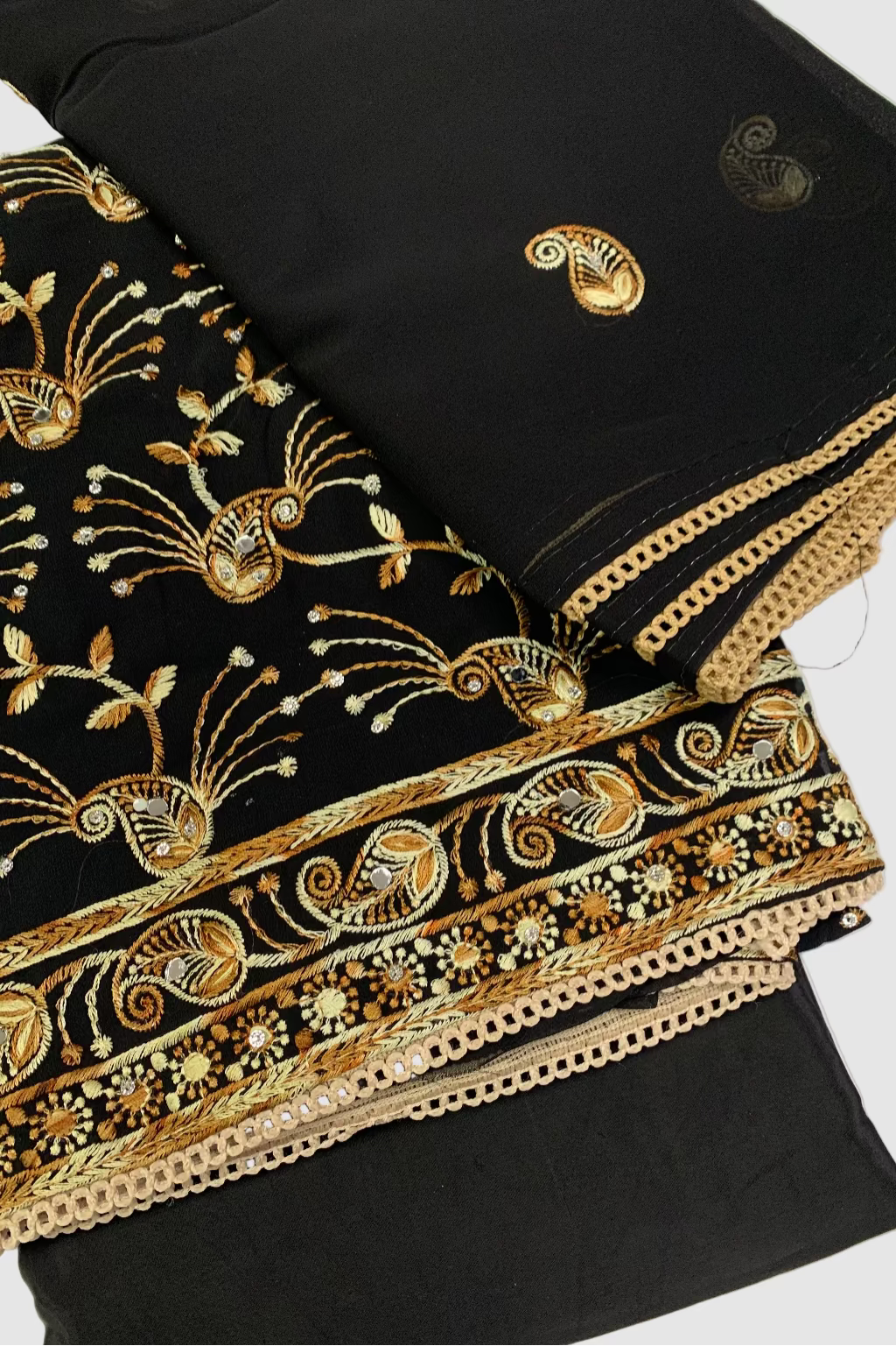 Black fabric with intricate gold embroidery on a white background