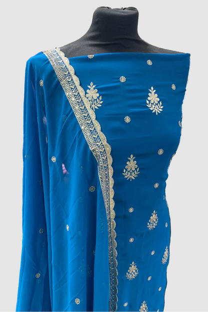 Blue embroidered dress fabric on a mannequin in a store setting