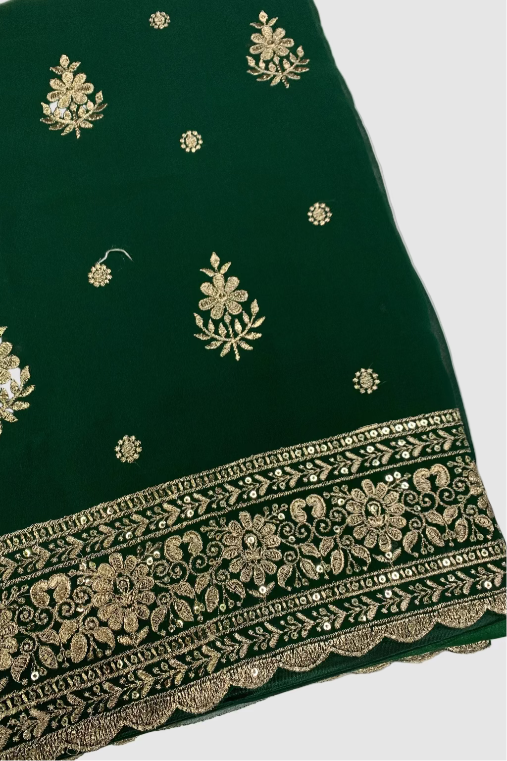 Green fabric with gold embroidery on a white background