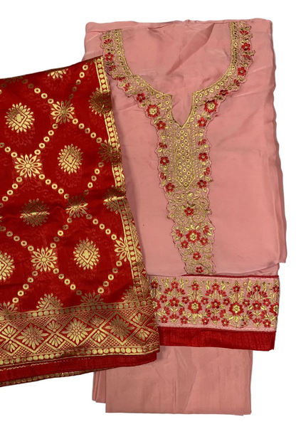 Pink and red embroidered traditional outfit on a white background