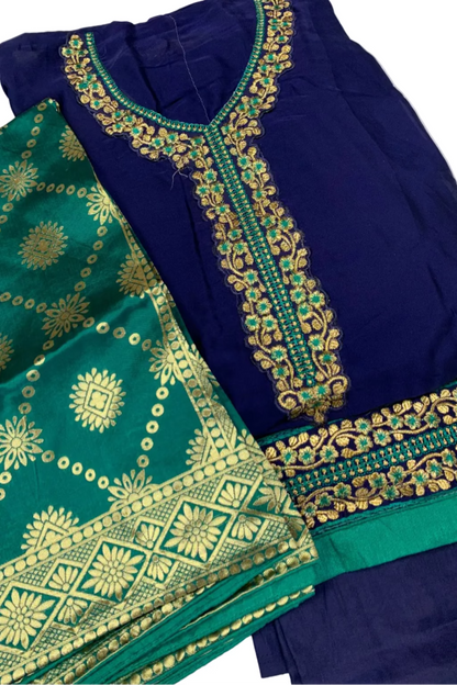 Blue and green traditional outfit with intricate gold embroidery on a white background