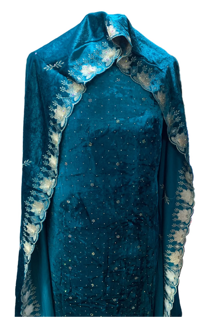 Teal dress with floral embroidery on a mannequin in a store setting