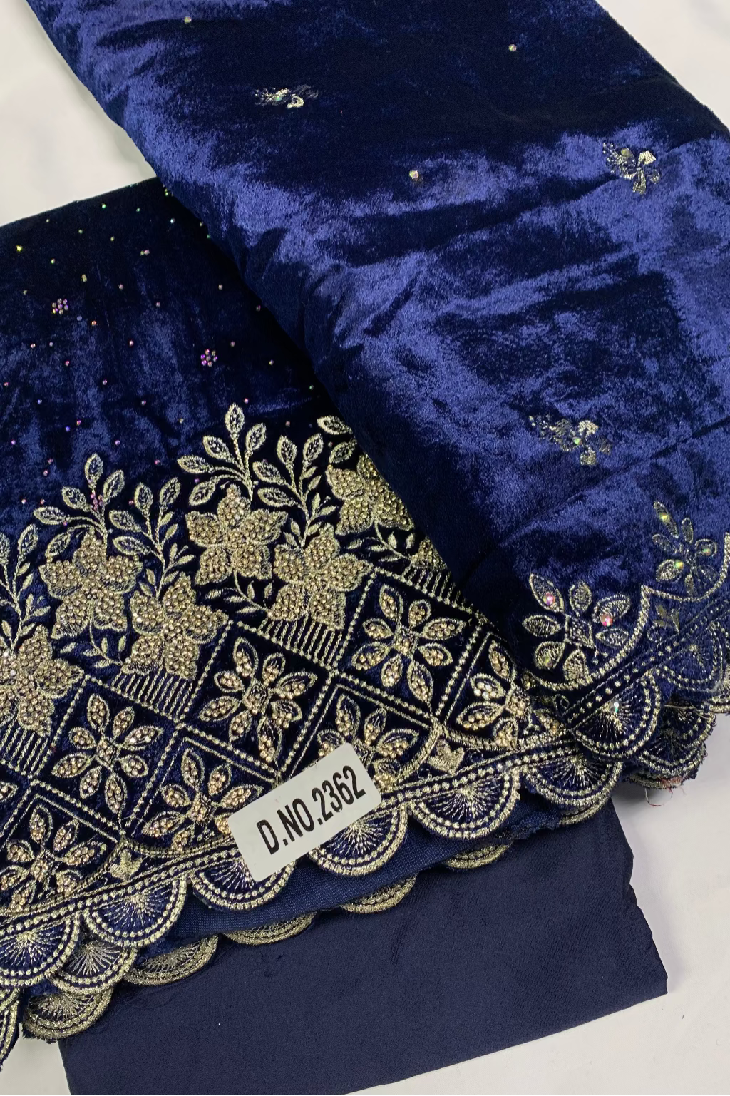 Navy blue fabric with gold embroidery on a white background