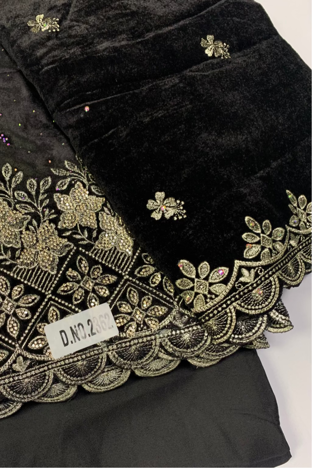 Black fabric with gold embroidery and decorative elements on a white background
