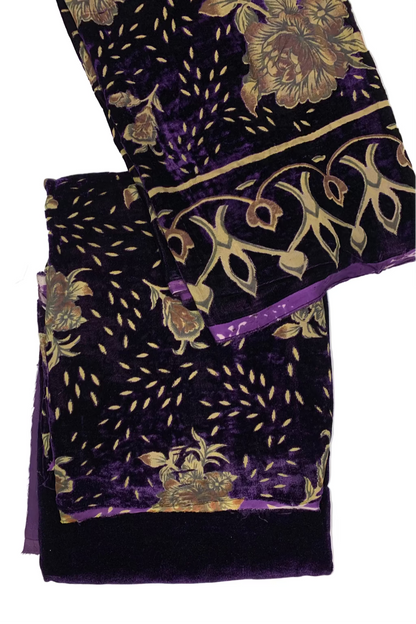 Purple fabric with gold floral and leaf patterns on a white background