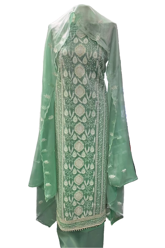 Green embroidered outfit on a mannequin in a store setting