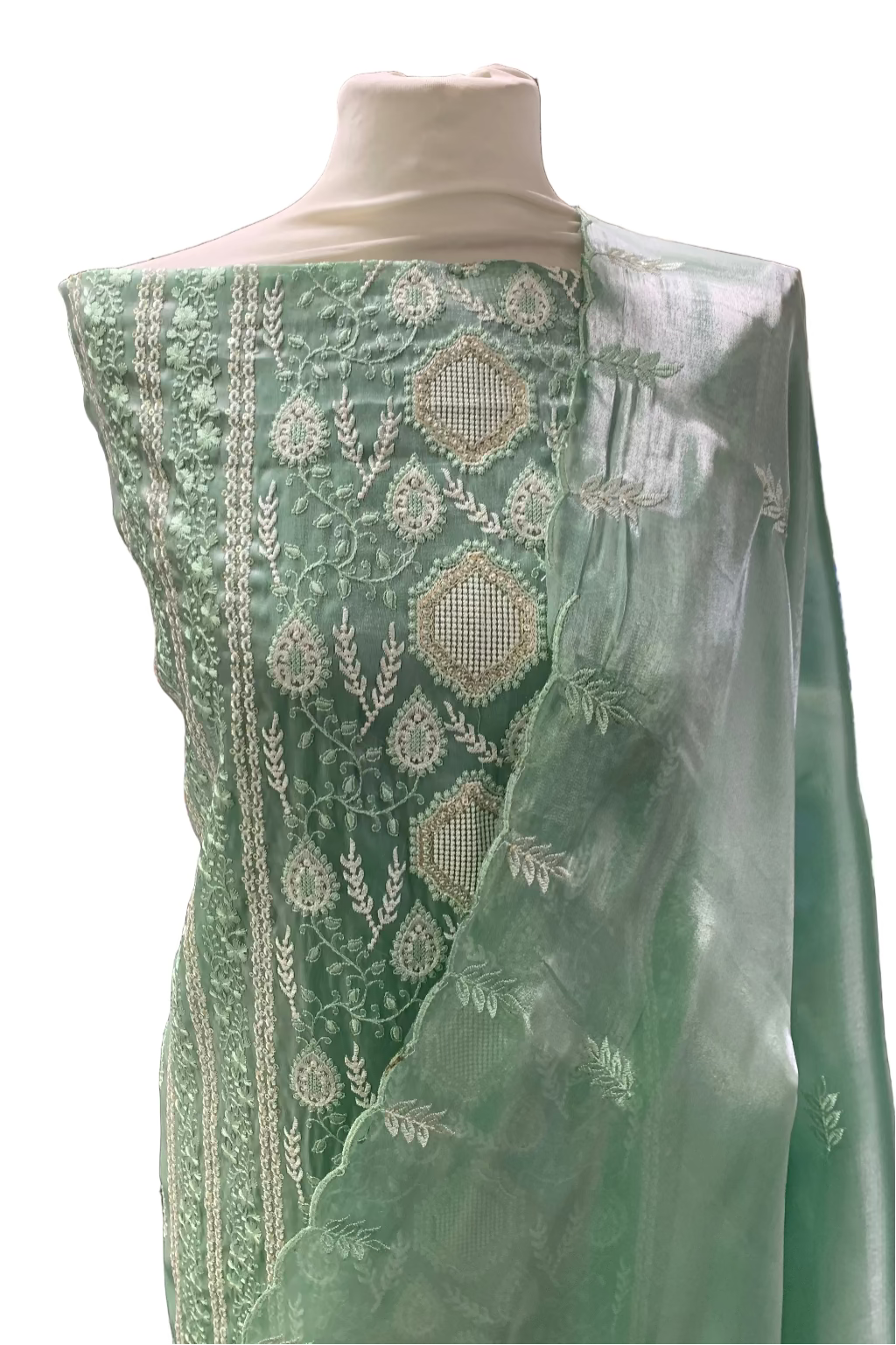 Green embroidered fabric on a mannequin in a store setting