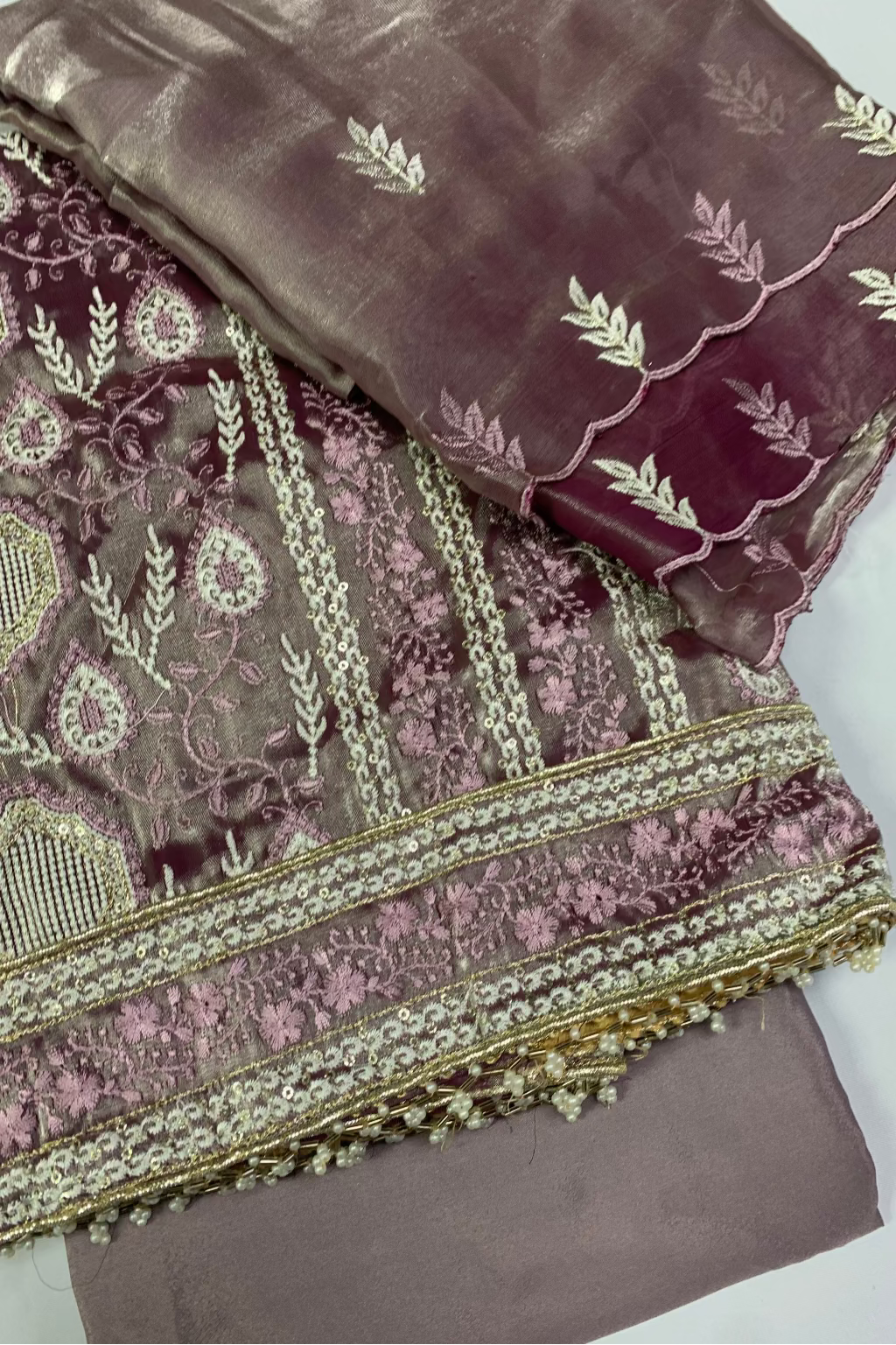 Two pieces of embroidered fabric with intricate patterns on a white background