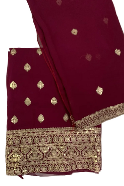 Maroon fabric with gold embroidery on a white background