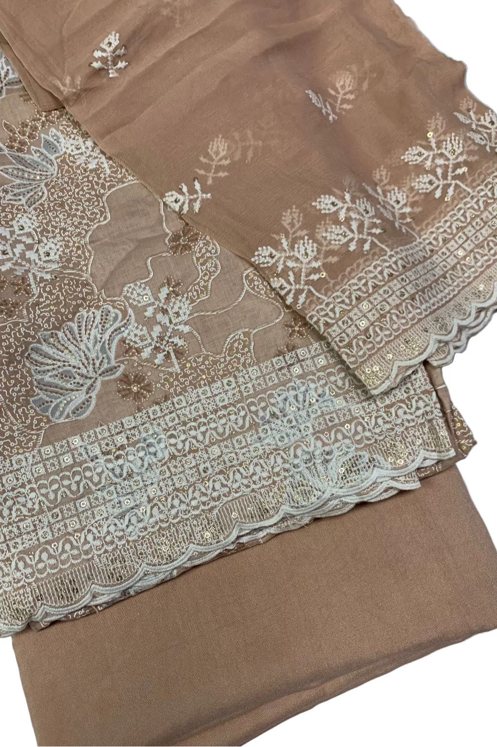 Peach fabric with intricate white lace and embroidery on a white background