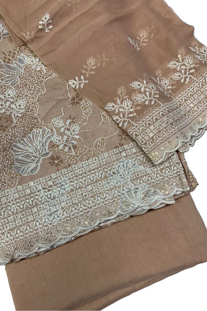 Peach fabric with intricate white lace and embroidery on a white background