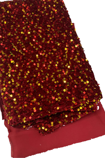 Red sequin fabric with gold sequins on a white background