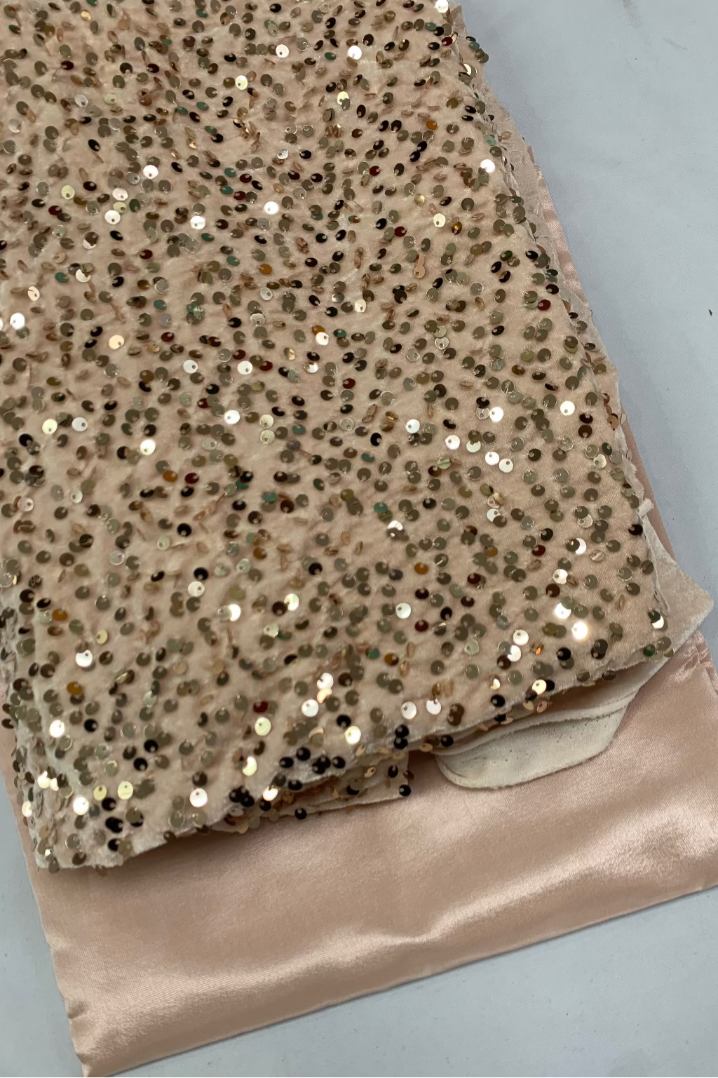 Peach sequined fabric with a plain background