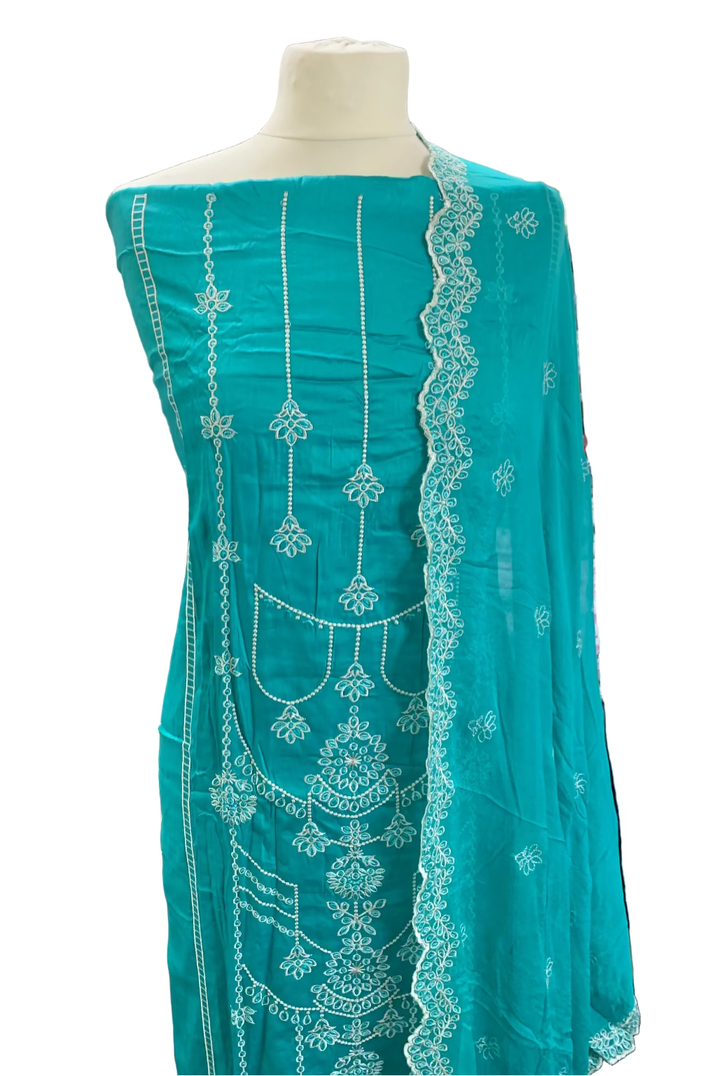 Turquoise embroidered fabric on a mannequin in a store setting