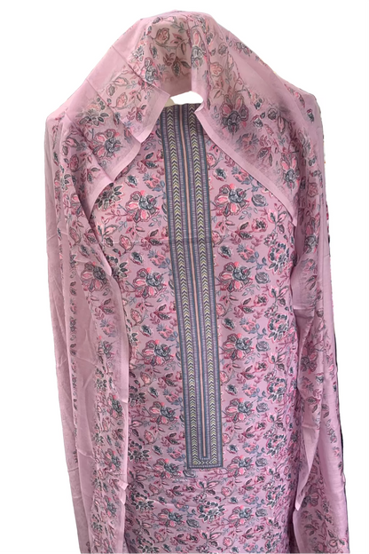 Pink floral dress with a patterned trim on a rack in a store setting