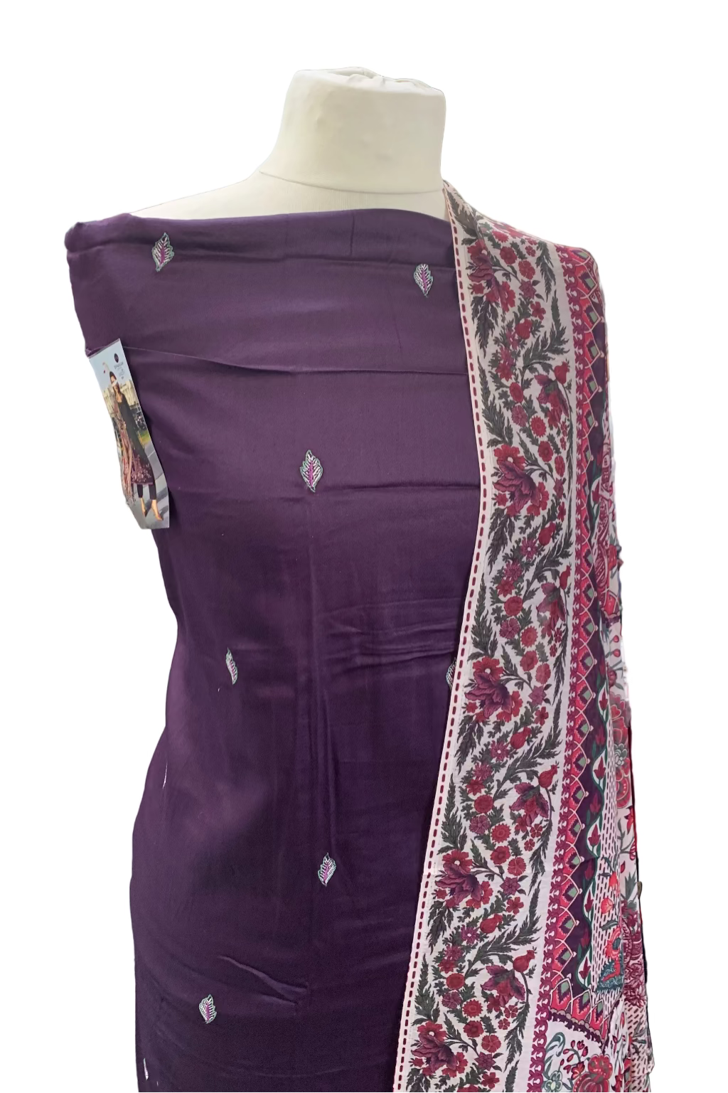 Mannequin wearing a purple garment with a patterned scarf in a store setting