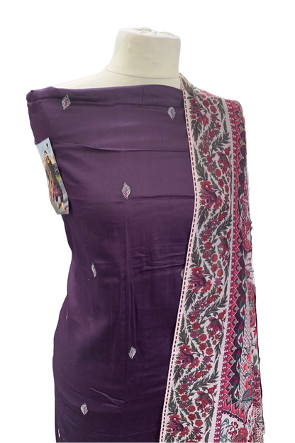 Mannequin wearing a purple garment with a patterned scarf in a store setting
