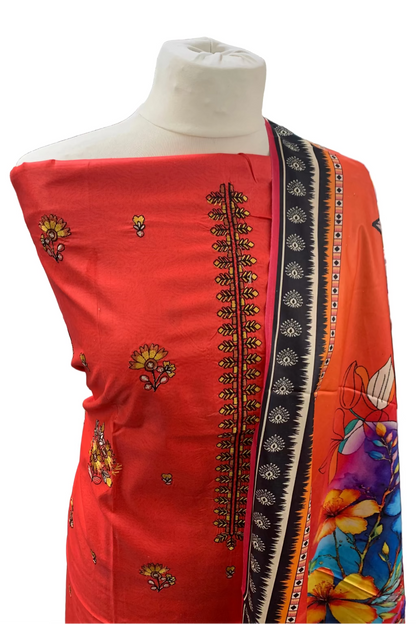 Red dress with intricate patterns on a mannequin in a store setting.