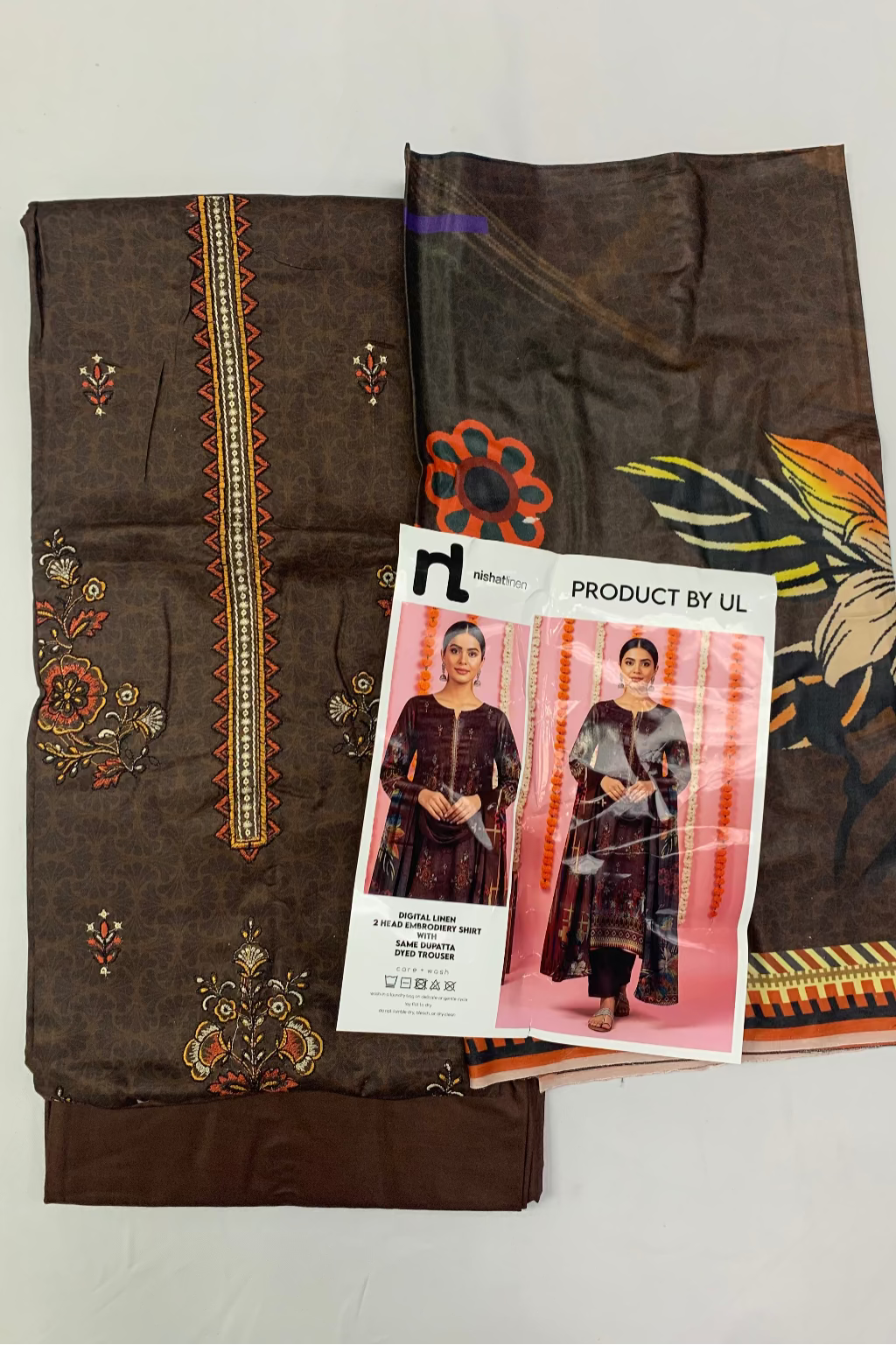 Brown fabric with intricate patterns and a product label on a light gray background