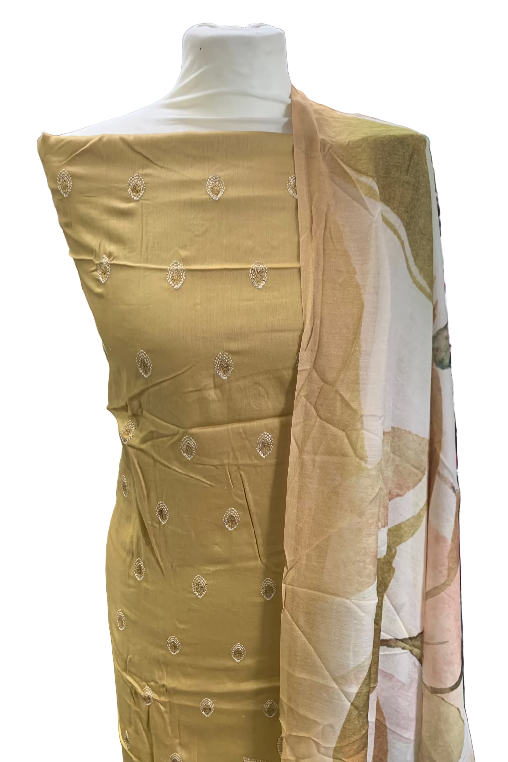 Mannequin wearing a light-colored fabric with button-like embellishments in a store setting.