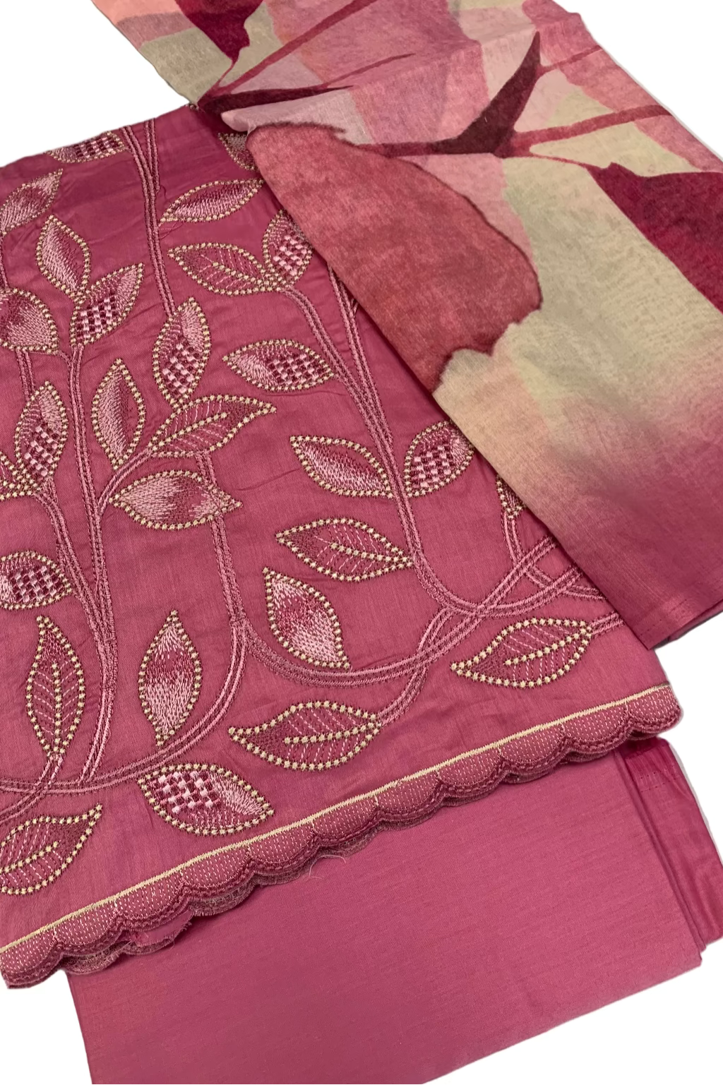 Pink fabric with embroidered patterns on a white background