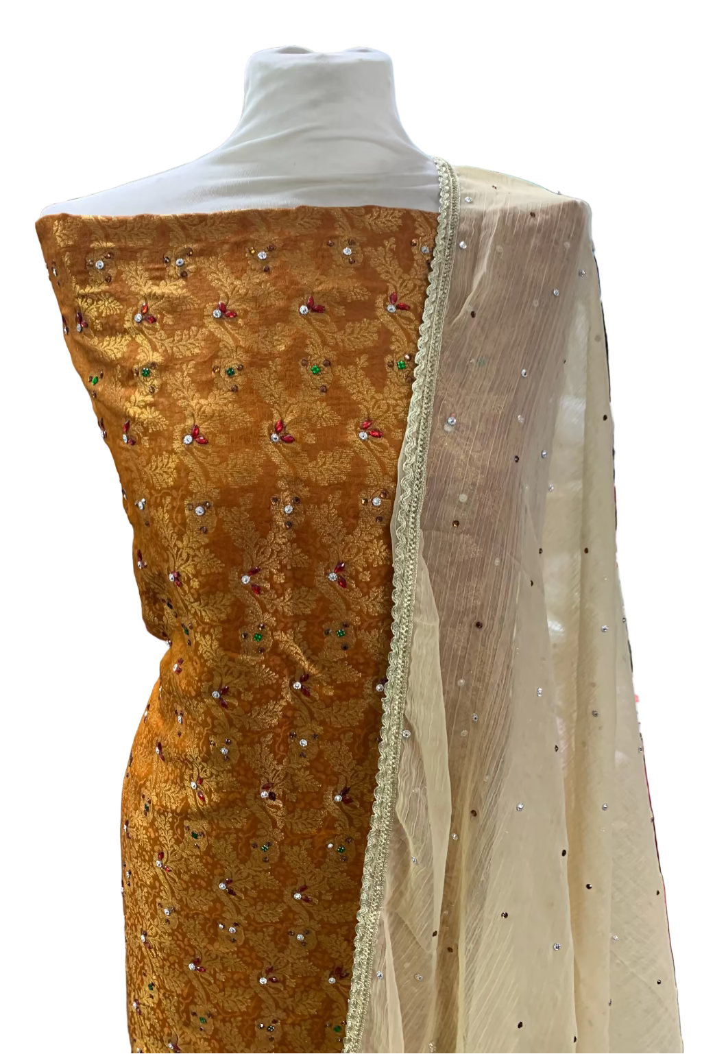 Gold embroidered fabric on a mannequin with a blurred store background