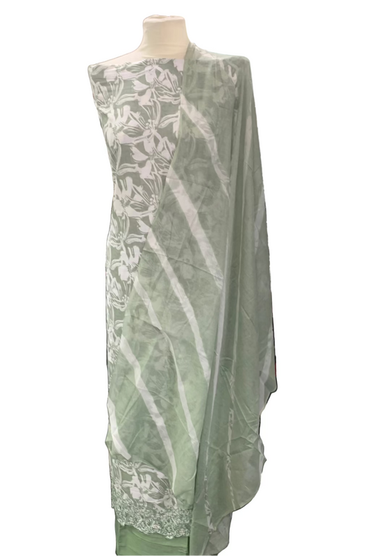 Mannequin wearing a light green suit with white floral patterns and embroidery detail