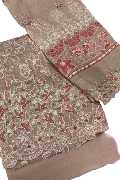 Pink fabric with intricate floral embroidery on a white background